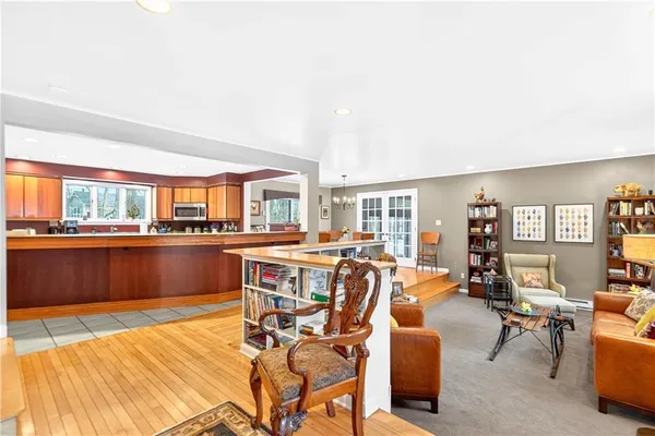 a living room with couches and kitchen view with wooden floor