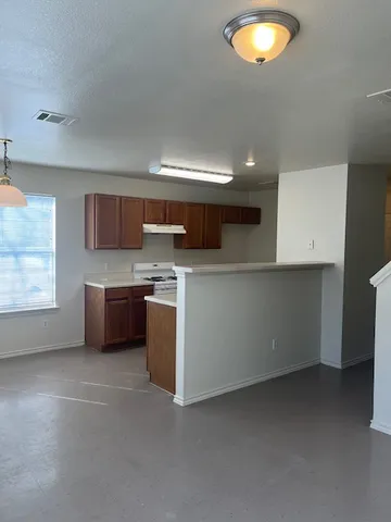 an empty room with windows & cabinet a kitchen view