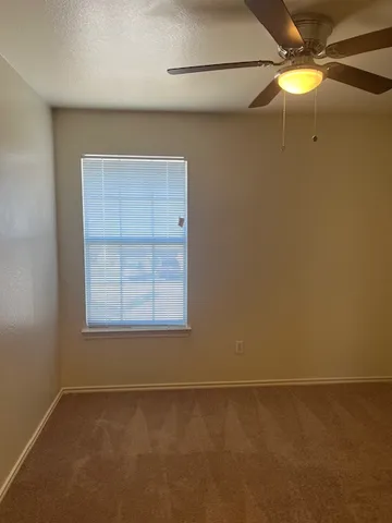 a view of an empty room with a closet and a window