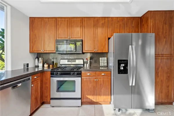 a kitchen with stainless steel appliances granite countertop a refrigerator and a stove top oven