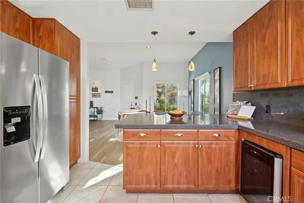 a kitchen with stainless steel appliances granite countertop a refrigerator a stove and a sink