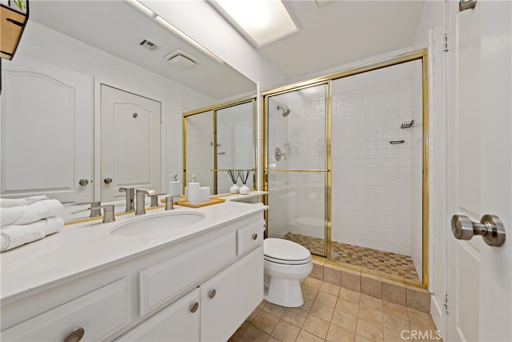 46 Pebble Beach Drive Rancho Mirage, CA 92270 - Photo 15 of 29 a bathroom with a double vanity sink toilet mirror and shower