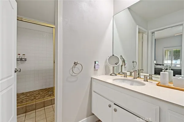 a bathroom with a double vanity sink mirror and shower