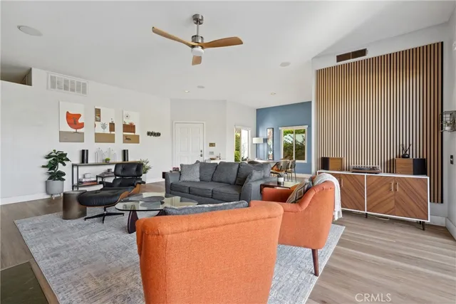 a living room with furniture kitchen view and a window