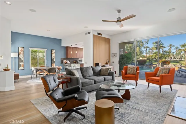 a living room with furniture kitchen view and a large window
