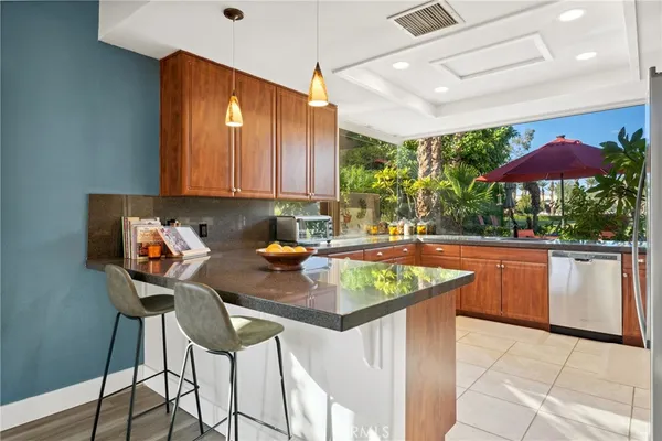 a kitchen with stainless steel appliances granite countertop a table chairs sink and cabinets