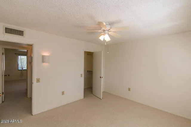 an empty room with a ceiling fan and a bathroom