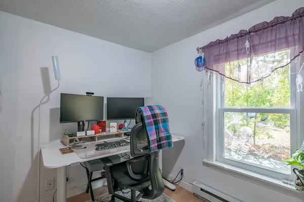 a view of a workspace with furniture and a window