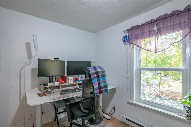 a view of a workspace with furniture and a window