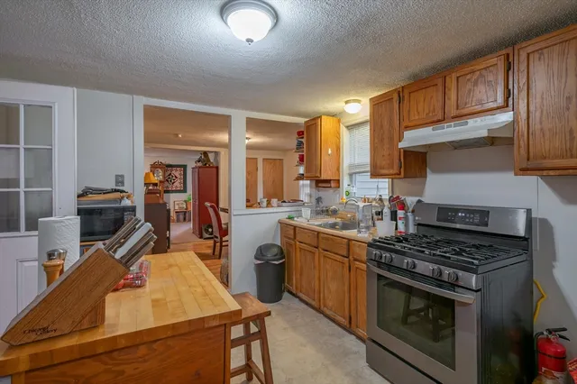 a kitchen with stainless steel appliances granite countertop a stove top oven a sink dishwasher and cabinets with wooden floor