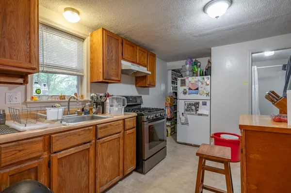 a kitchen with stainless steel appliances granite countertop a sink stove and refrigerator