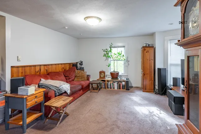 a living room with furniture a window and a flat screen tv