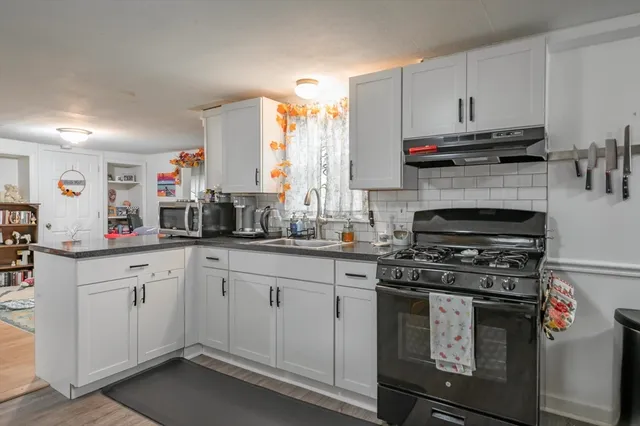 a kitchen with stainless steel appliances a stove a sink and a microwave