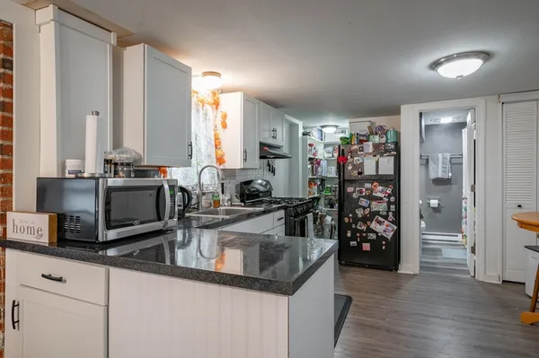 a kitchen with stainless steel appliances granite countertop a sink and a refrigerator