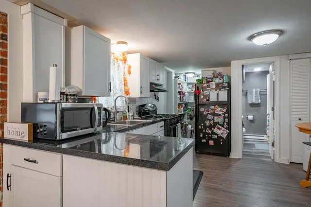 a kitchen with stainless steel appliances granite countertop a sink and a refrigerator