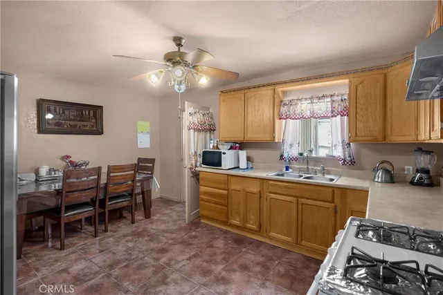 a kitchen with granite countertop a refrigerator oven a sink and dishwasher