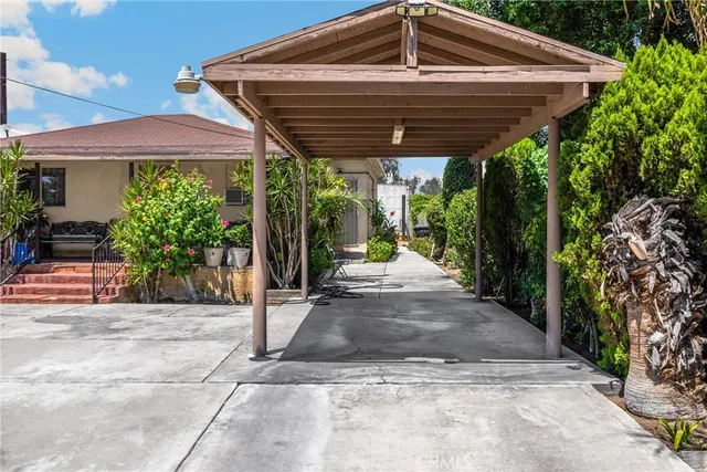 a view of a backyard with table and chairs under an umbrella with a small yard