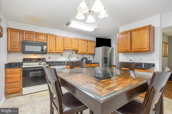 a kitchen with a stove a refrigerator and a dining table
