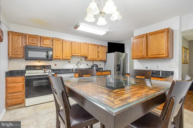 a kitchen with a stove a refrigerator and a dining table