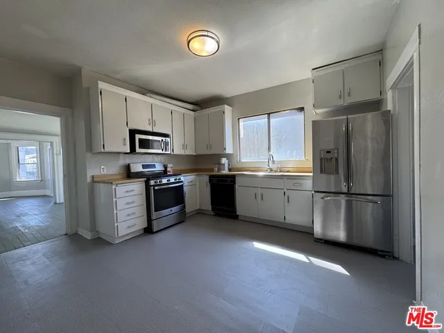 a kitchen with a refrigerator a sink and cabinets