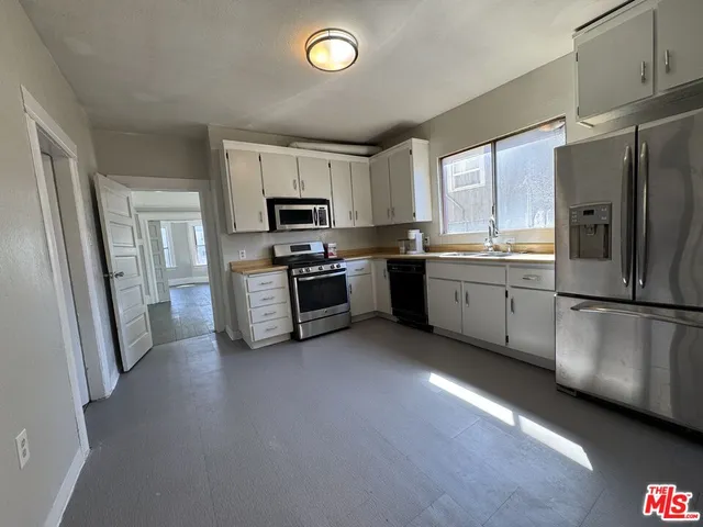 a kitchen with stainless steel appliances a refrigerator stove microwave and sink