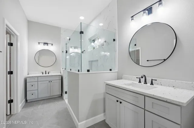 a bathroom with a granite countertop double vanity sink and a mirror