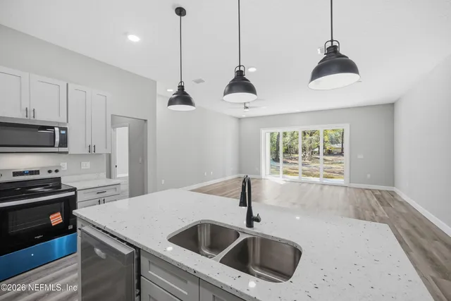 a kitchen with stainless steel appliances granite countertop a sink a stove a refrigerator and a granite counter tops