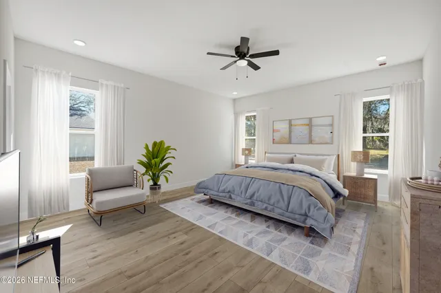 a spacious bedroom with a bed a couch and a potted plant