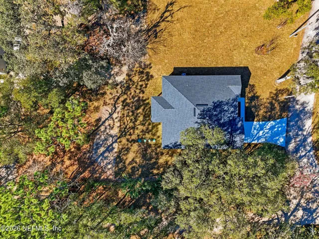 an aerial view of a house with a yard and lake view