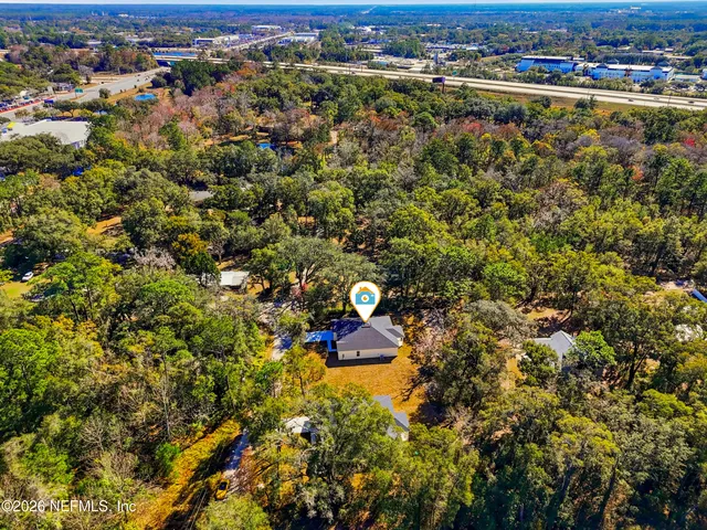 an aerial view of residential houses with outdoor space and trees
