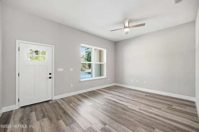 wooden floor in an empty room with a window