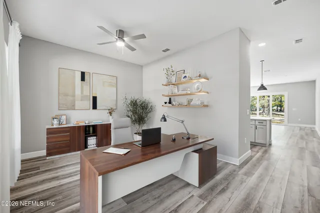 a room with kitchen island a wooden floor and ceiling fan