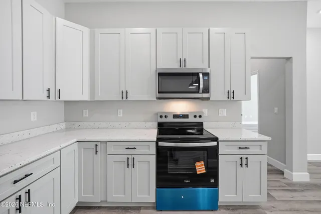 a kitchen with white cabinets and stainless steel appliances