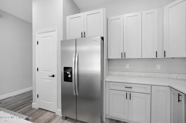 a kitchen with cabinets and a refrigerator