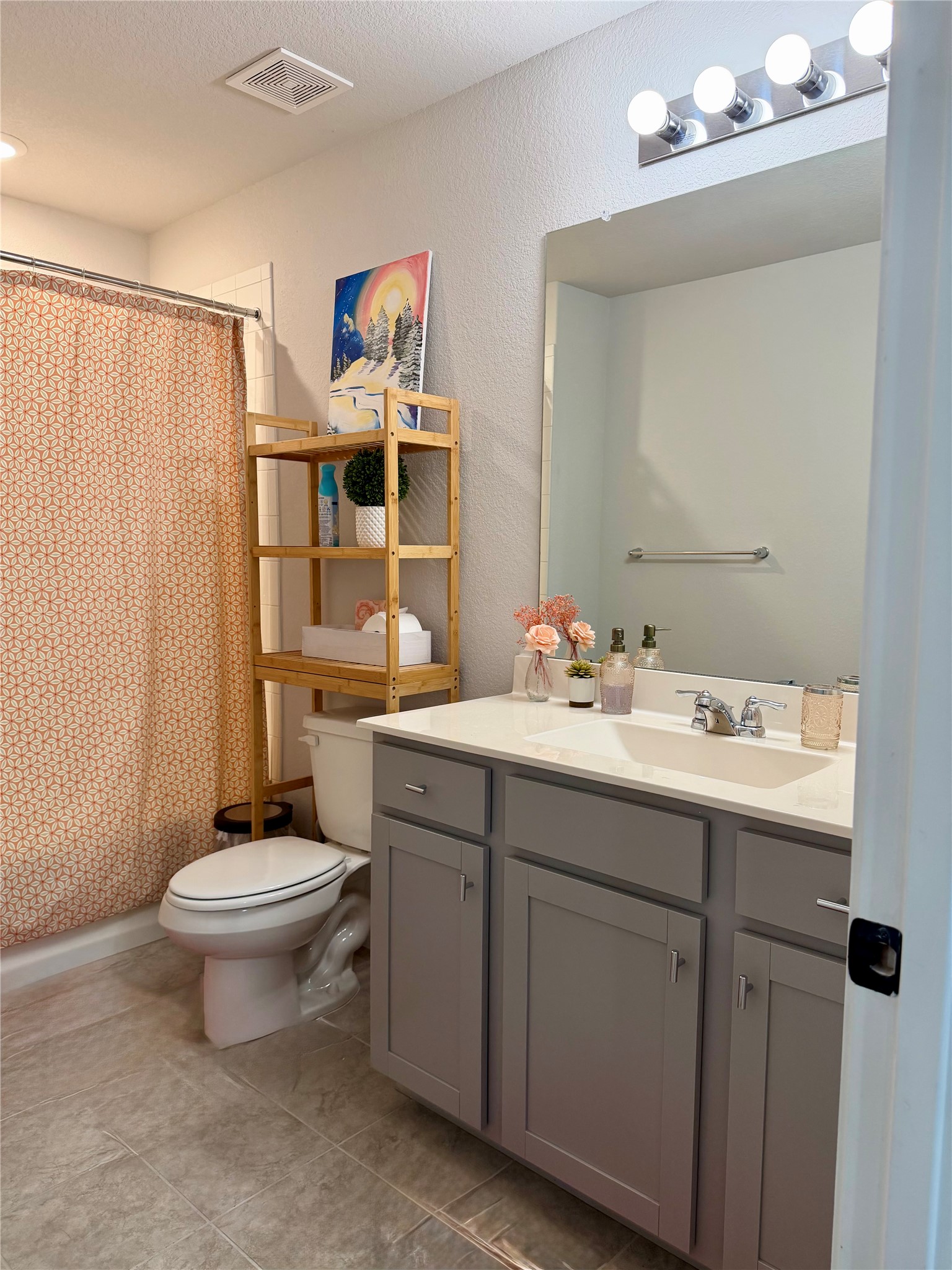 503 Gray Fox Loop Hutto, TX 78634 - Photo 16 of 23 Full bathroom featuring a single vanity with a white countertop and gray cabinetry, a wall-mounted mirror with vanity lighting, and light-toned tile flooring