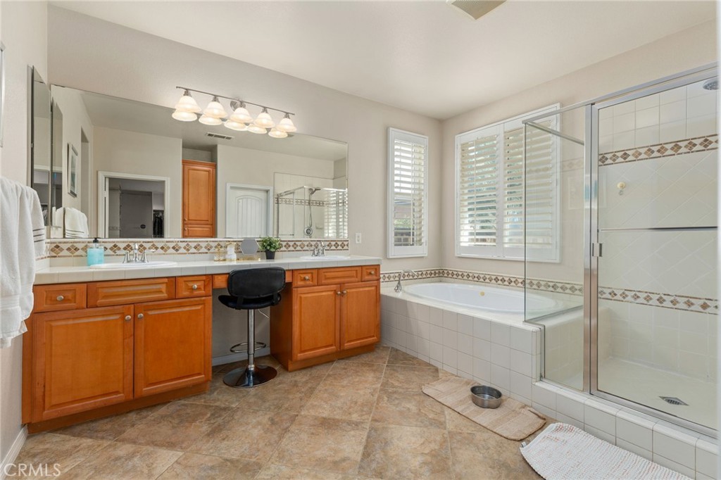 30355 Lamplighter Lane Menifee, CA 92584 - Photo 12 of 31 a spacious bathroom with a granite countertop sink mirror and a bathtub