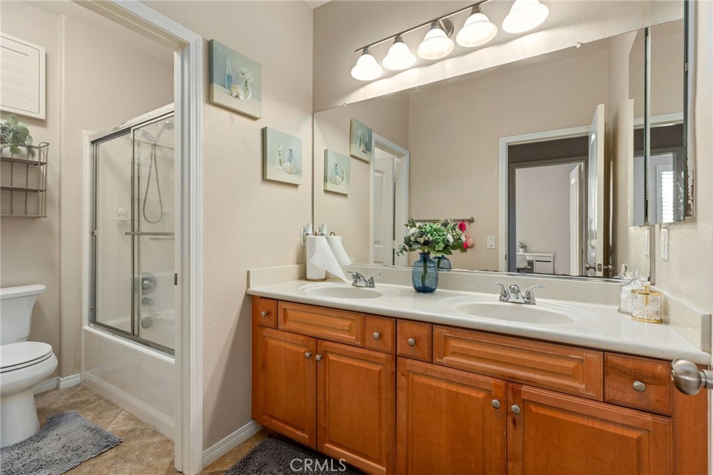 30355 Lamplighter Lane Menifee, CA 92584 - Photo 15 of 31 a spacious bathroom with a granite countertop sink a toilet and a mirror
