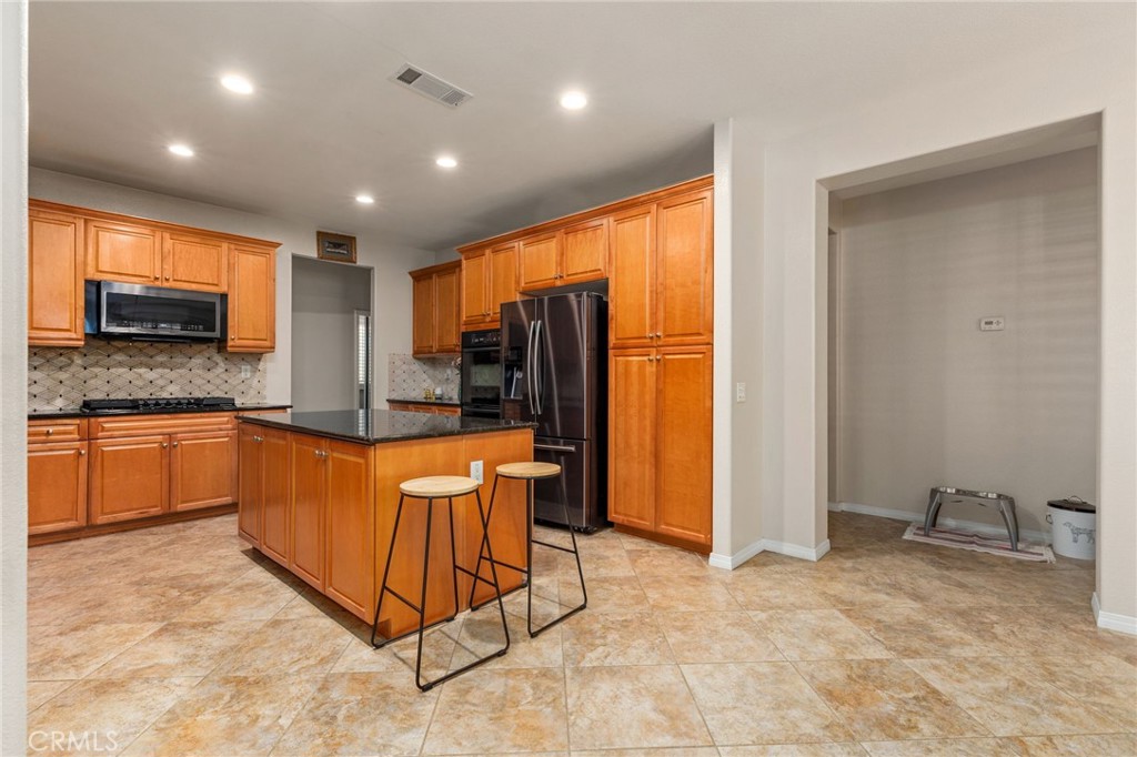 30355 Lamplighter Lane Menifee, CA 92584 - Photo 8 of 31 a large kitchen with a large counter top sink and stainless steel appliances