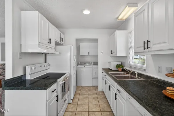 a kitchen with stainless steel appliances granite countertop a sink a stove and a refrigerator