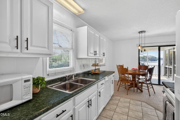 a kitchen with sink cabinets and dining table chair