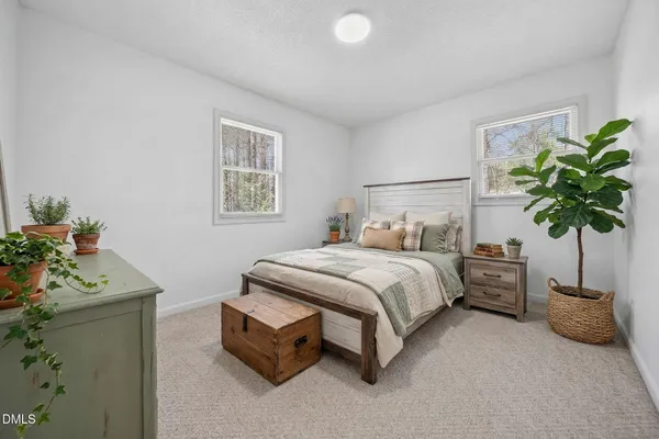 a bedroom with a bed and a potted plant