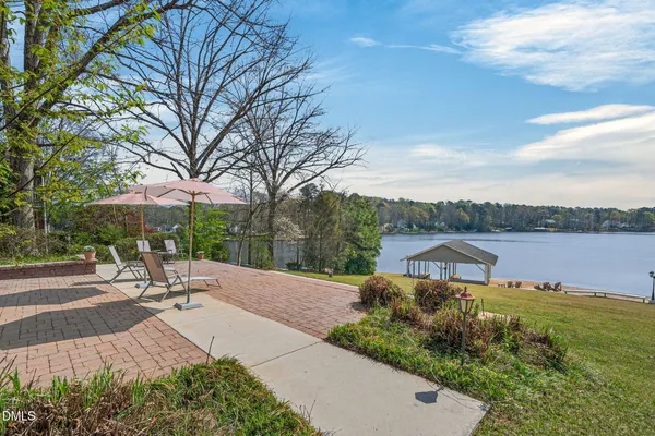 a view of a lake with a table and a table and chair under an umbrella