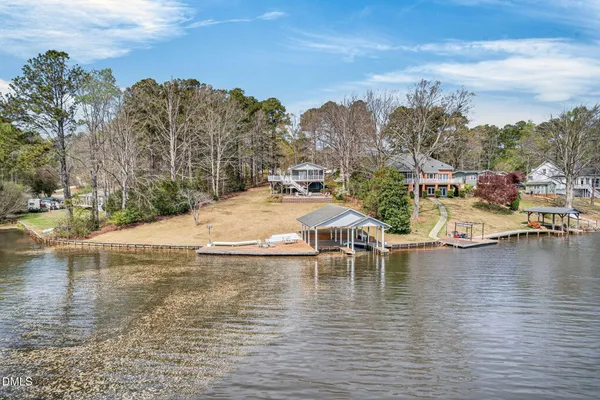 an aerial view of a house with a yard and lake view