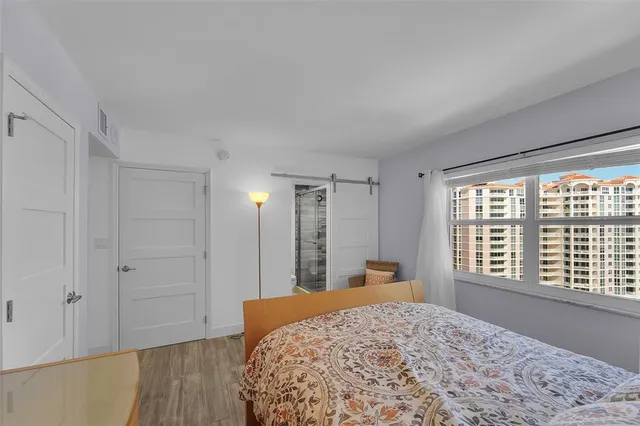 a bedroom with a large bed and wooden floor