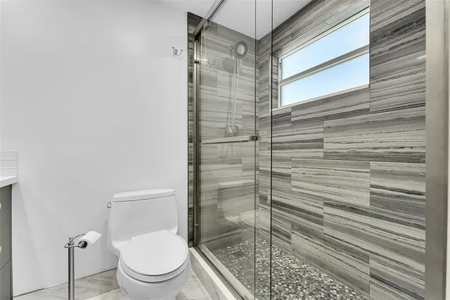 a bathroom with a toilet and a shower