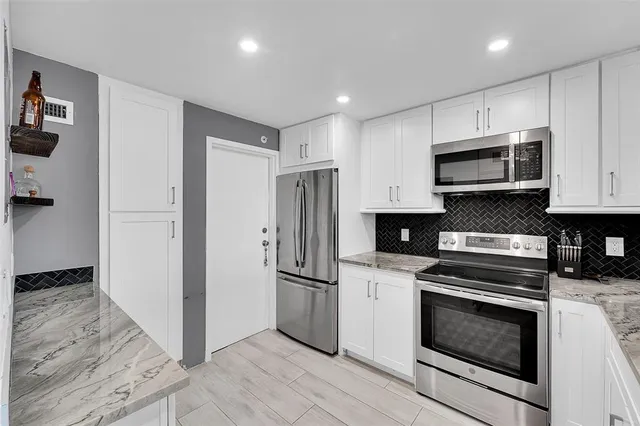 a kitchen with stainless steel appliances a stove a microwave and a refrigerator