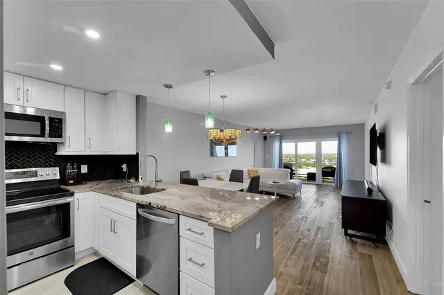 a kitchen that has a lot of cabinets in it and wooden floors