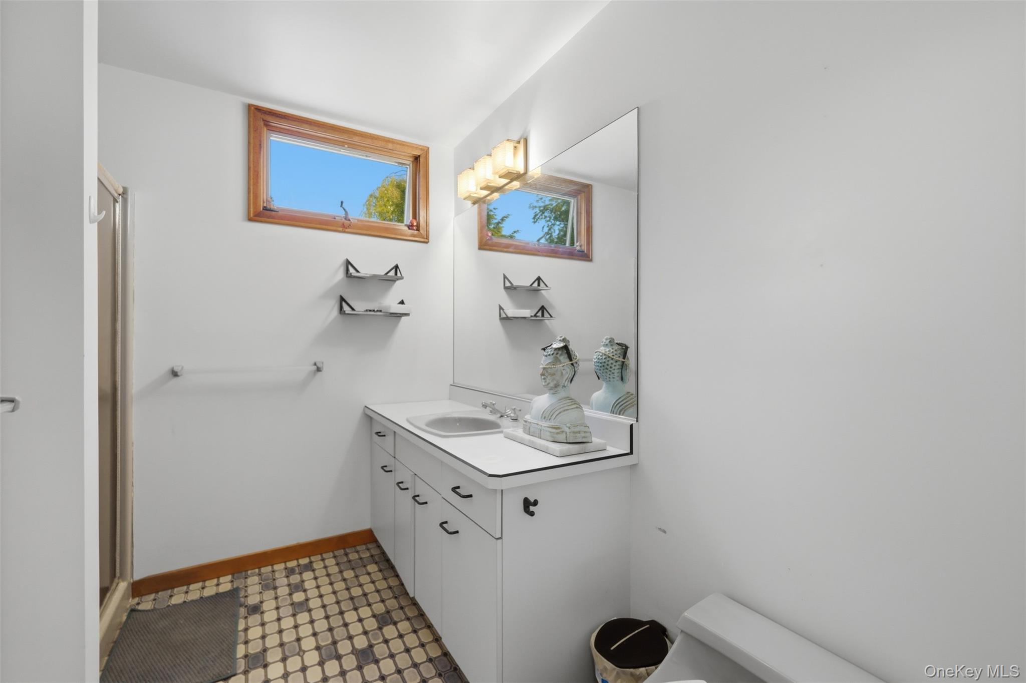 985 Craigville Road Chester, NY 10918 - Photo 24 of 36 Bathroom with a white vanity featuring integrated sink, large wall mirror, and a three-light vanity fixture
