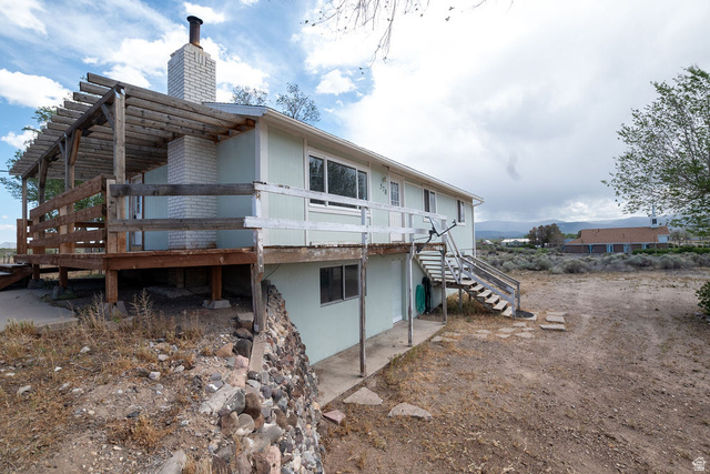570 West Main Street Beaver, UT 84713 - Photo 4 of 43 Two-story exterior with light blue siding, featuring an expansive wood deck with a pergola
