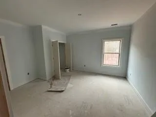 an empty room with a fireplace and windows